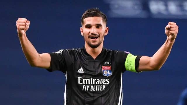 Houssem Aouar celebrates with a smile and his hands up in the air
